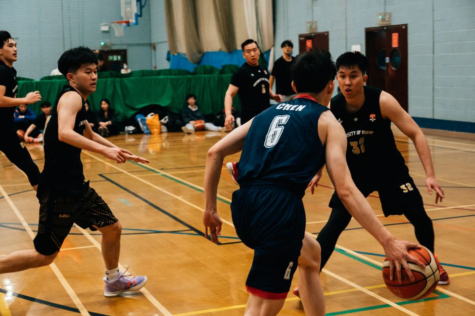 Energetic scene of a competitive indoor basketball game with players in action.